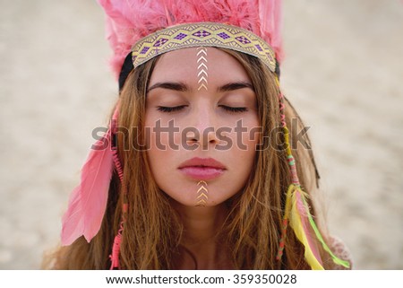 Beauty portrait of the girl with flash tattoo and coloured feather hat