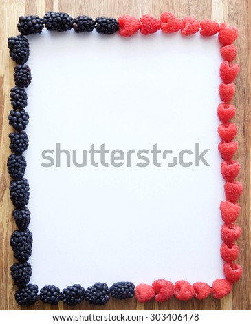 Menu sheet of white paper with frame of berries on rustic wooden background