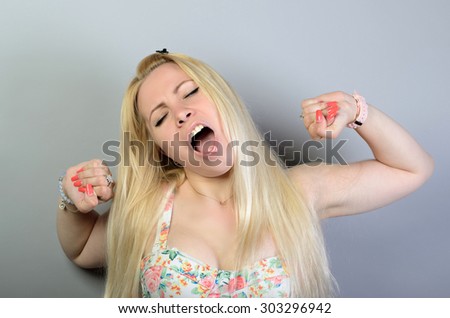 The woman yawns. On a gray background.