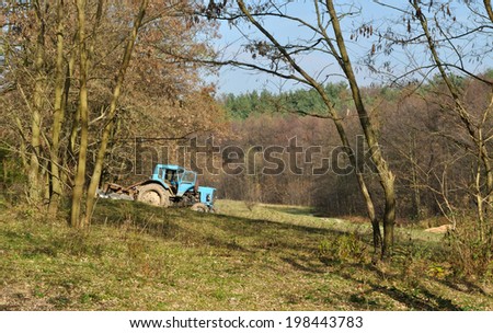 tractor standing near the trees