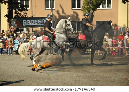 VRATIMOV, CZECH REPUBLIC-SEPTEMBER 7: Mounted policemans jumping across the fire.rescue and emergency services open day. Units at car crash training on September 7, 2013 in VRATIMOV, Czech republic.