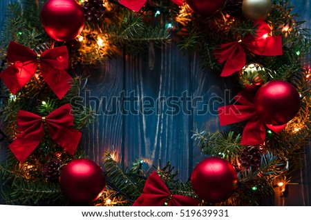 Christmas handmade wreath on a wooden background. Festive lights of garland. Interior decoration