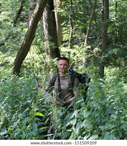 Young Man with Backpack traveling deep in Jungle