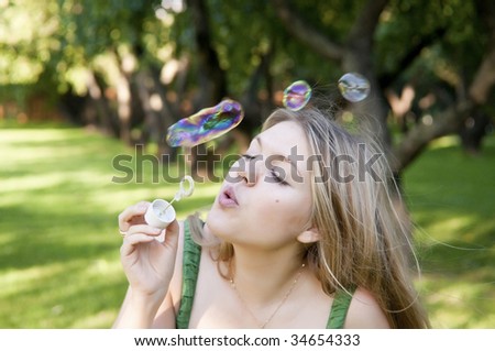 blonde girl makes soap bubbles