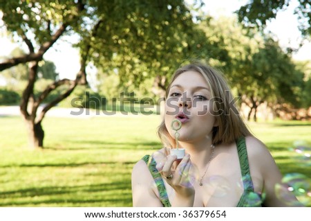 Young girl inflating soap bubbles