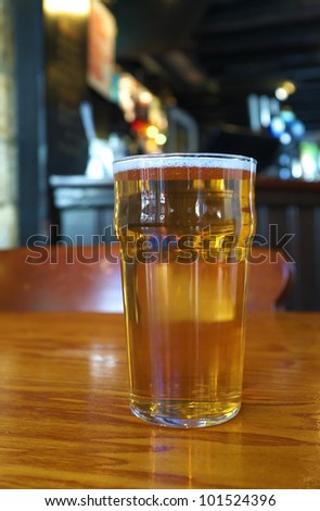A pint of ale against the background of a traditional English pub