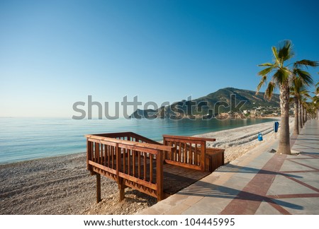 Wooden walkway to access a sunny Mediterranean beach