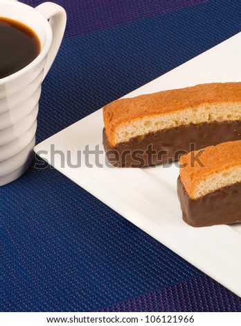 Chocolate coated sponge fingers and a cup of coffee