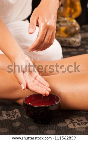 Massage therapist moistening her hands in oil