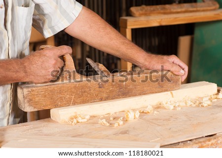 Traditional plane at work in carpenter hands