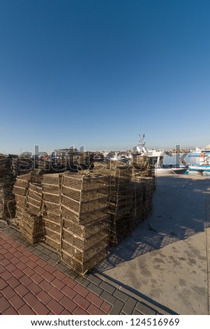 Cages used for aquaculture piled up on a fishing harbor pier