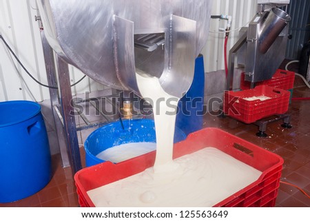 Machine pouring fresh cheese during the production process