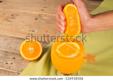 Hand squeezing fresh juice out of an orange