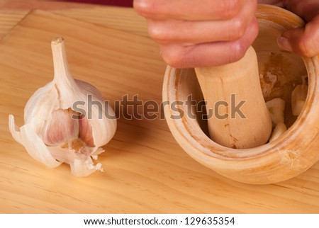 Processing garlic inside a mortar to make traditional alioli sauce
