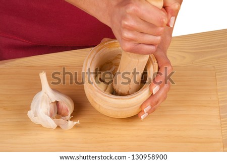 Processing garlic inside a mortar to make traditional alioli sauce
