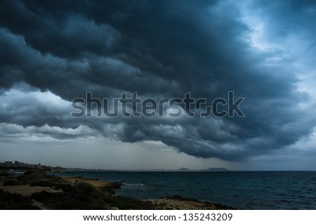 Low threatening  storm clouds hanging over a coastal area