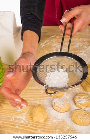 Icing sugar being  powdered on homemade cookies