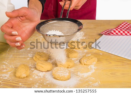 Powdering icing sugar on freshly made cookies