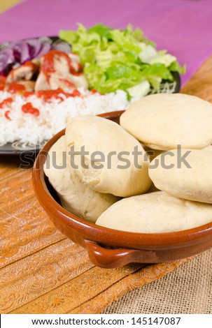 Pita bread, plate with kebab ingredients in the background