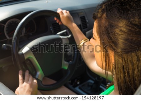 Female driver inside the car behing the steering wheel