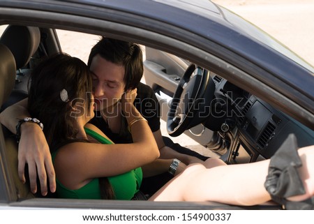 Romantic scene with a young couple inside a car