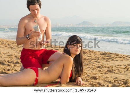 Guy enjoying rubbing suntan lotion onto her back