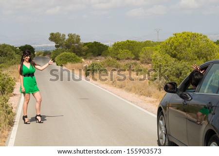 Female hitchhiker being successful in stopping a car
