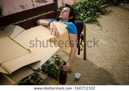 Guy sleeping off a tough hangover on a park bench