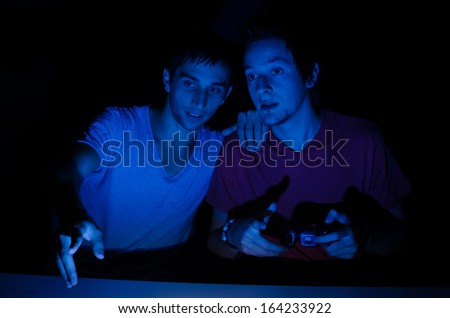 Two friends in front of a computer screen gaming