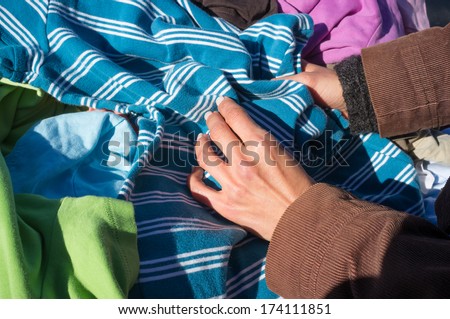 Female hands rummaging on a second hand clothes stall