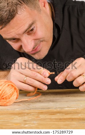 Guy struggling with a thread far to big for the needle