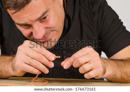 Guy having a hard time with needle and thread