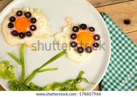 Sunny side up eggs decorated with vegetables, kid food