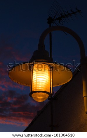 Old street lamp at dusk in a Mediterranean fishing village
