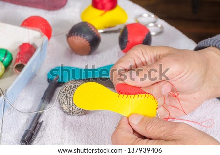 Leather craft, male hands sewing  traditional sport balls