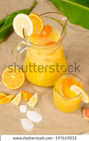 Freshly squeezed fruit juice on beach snad
