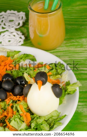 Funny salad decorated with penguins, a way to make vegetables attractive to kids