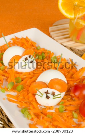 Funny carrot salad with boiled eggs resembling mice, kid food