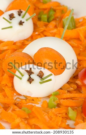 Funny carrot salad with boiled eggs resembling mice, kid food