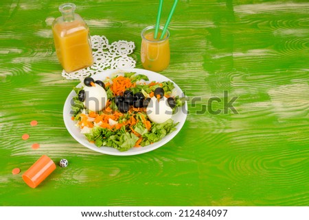 Fresh salad with eggs decorated as penguins, funny kid food