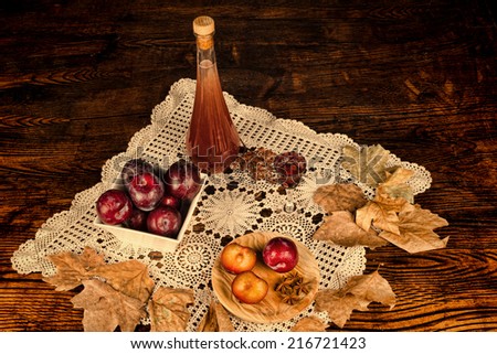 Homemade plum brandy and ingredients in an autumnal setting