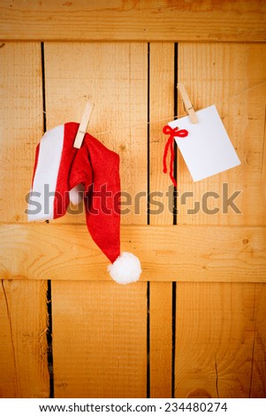 Wish list and Santa  cap hanging on a rustic wooden door