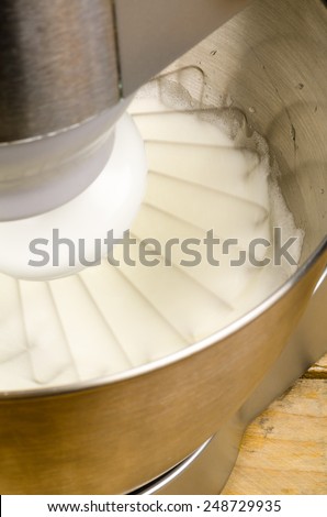 Egg whites being whisked inside a modern food processor