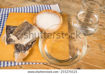 Several pieces of dried cod being desalted in fresh water