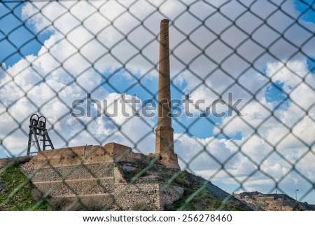 Old industrial factory ruin photographed through its surrounding fence