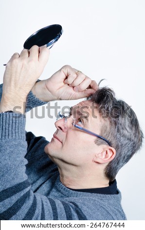 Guy checking out his hair with a mirror