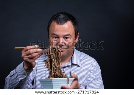 Guy experiencing how difficult it can be to eat with chopsticks