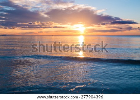 Calm waters of a Mediterranean beach at sunrise