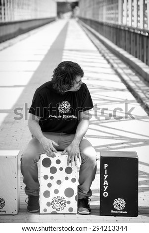 Percussionist sitting on a cajon flamenco playing it with his bare hands