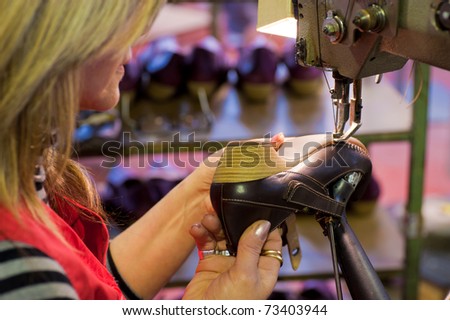 Experienced worker sewing leather shoes in a production line